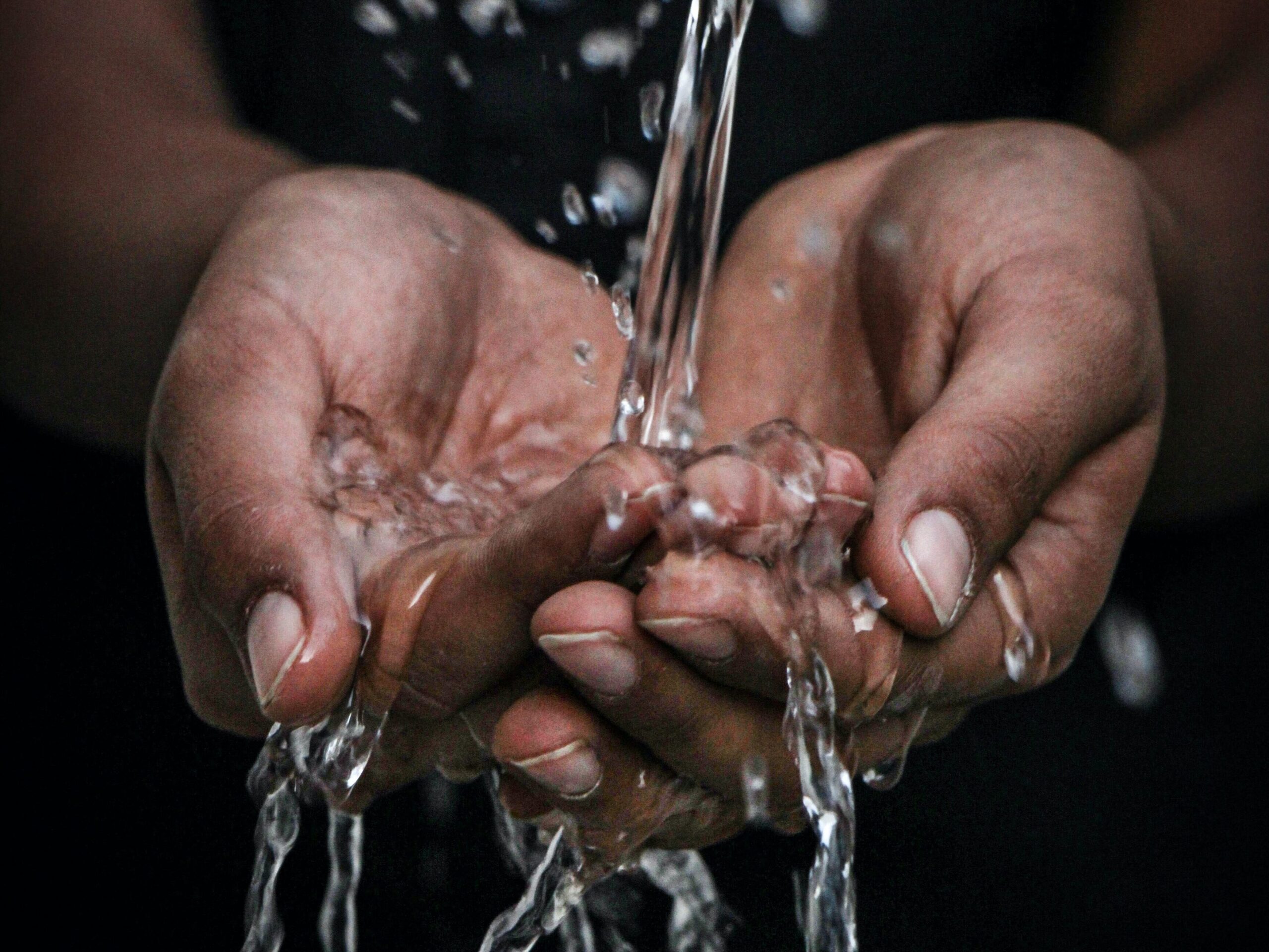 Hands catching stream of clean water