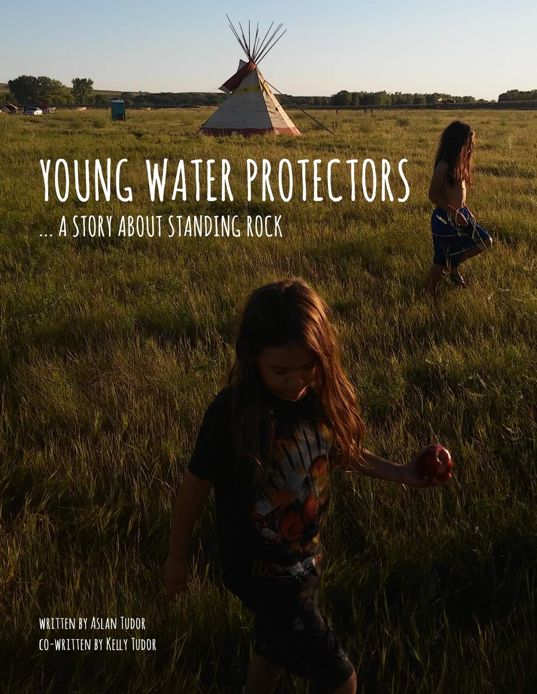 Cover of the book Young Water Protectors: A Story About Standing Rock. Features two youth on a grassy plain.